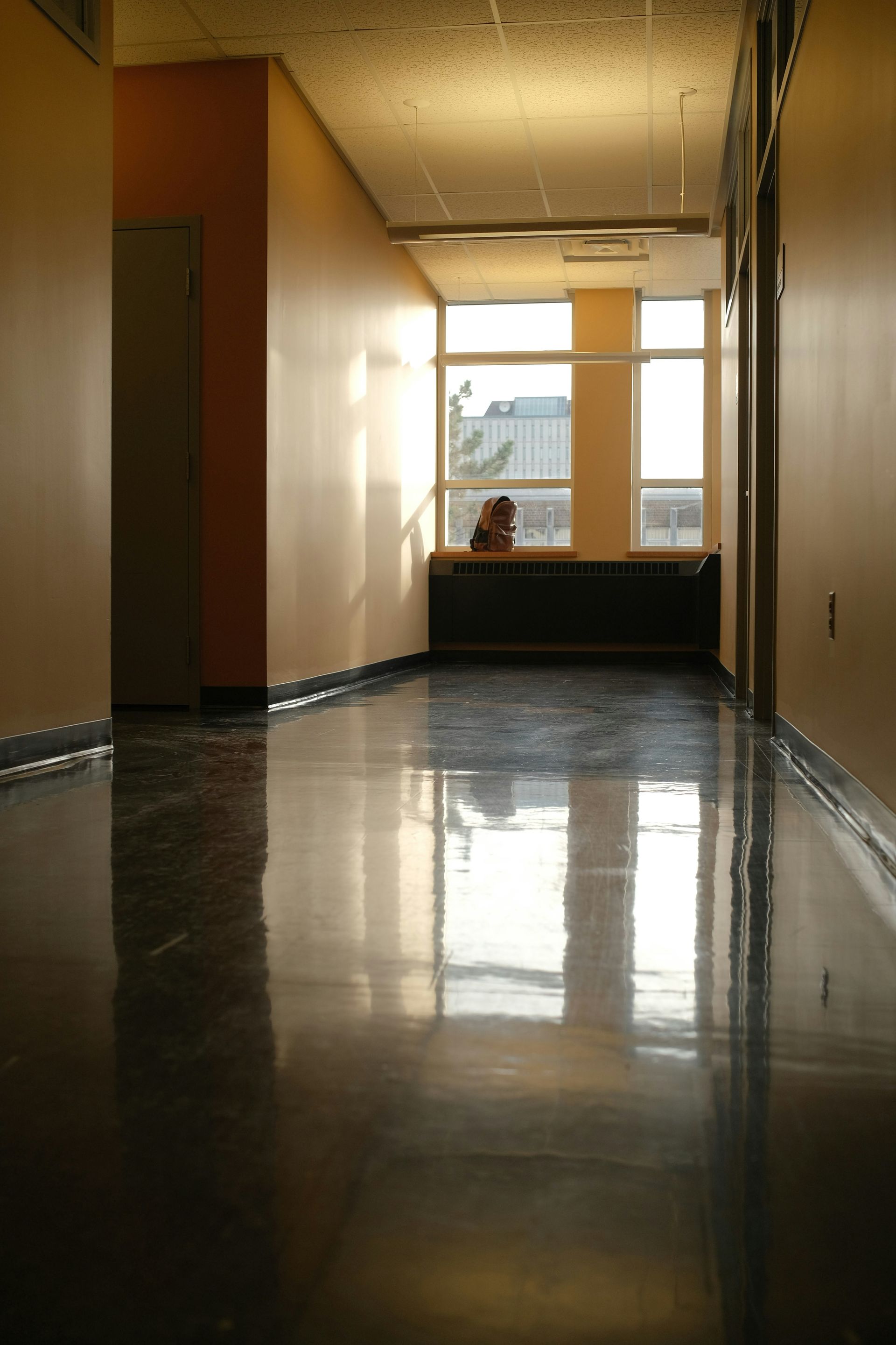 Empty hallway reflecting sunlight and shadows.